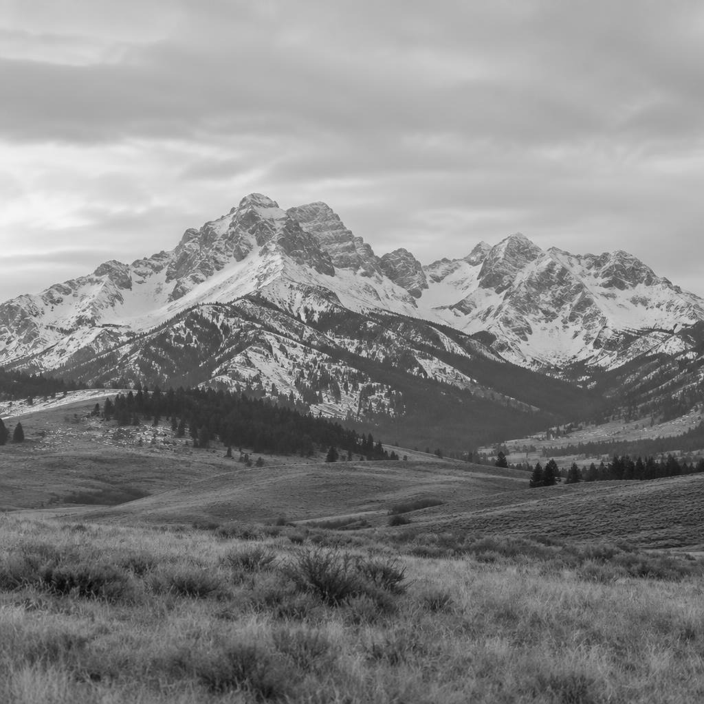 Black and white photo of the snowy Bridger Range above the foothills near Bozeman, Montana